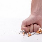 Stop smoking. Close up of male hand breaking cigarettes with his fist. Isolated and copy space in left side